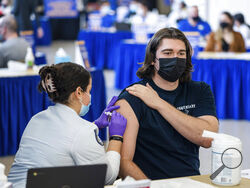 FILE - Pitt student Michael Burke, 21, gets a COVID-19 booster shot from nursing student Colette Sayegh, on Wednesday, Jan. 12, 2022, at the Peterson Events Center in Oakland, Pa. The COVID-19 booster drive in the U.S. is losing steam, worrying health experts who have pleaded with Americans to get an extra shot to shore up their protection against the highly contagious omicron variant. (Andrew Rush/Pittsburgh Post-Gazette via AP, File )