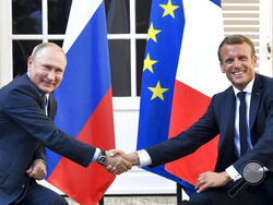 FILE - French President Emmanuel Macron, right, shakes hands with Russian President Vladimir Putin after their meeting at the fort of Bregancon in Bormes-les-Mimosas, southern France, on Aug. 19, 2019. Rarely in recent years has the Kremlin been so popular with European visitors. French President Emmanuel Macron arrives Monday, Feb. 7, 2022. The Hungarian prime minister visited last week. And in days to come, the German chancellor will be there, too. (Gerard Julien, Pool via AP, File)