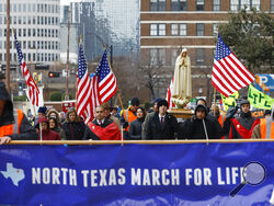 FILE - Protesters walk along Jackson St. during the North Texas March for Life, celebrating the passage and court rulings upholding the Texas law known as Senate Bill 8, on Saturday, Jan. 15, 2022, in Dallas. Abortions in Texas fell by 60% in the first month under the most restrictive abortion law in the U.S. in decades. That's according to the fist figures released by Texas health officials since the law known as Senate Bill 8 took effect in September. (Shafkat Anowar/The Dallas Morning News via AP)