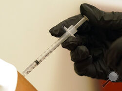 A person is injected with her second dose of the Pfizer COVID-19 vaccine at a Dallas County Health and Human Services vaccination site in Dallas, Thursday, Aug. 26, 2021. Federal health regulators on Friday, Feb. 11, 2022 delayed next week's public meeting to review Pfizer’s COVID-19 vaccine for children under 5, saying they want to see more data. (AP Photo/LM Otero, File)