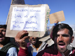 Afghan protesters hold placards and shout slogans against U.S. during a protest condemning President Joe Biden's decision, in Kabul, Afghanistan, Saturday, Feb. 12, 2022. President Biden signed an executive order, Friday, Feb. 11, 2022, to create a pathway to split $7 billion in Afghan assets frozen in the U.S. to fund humanitarian relief in Afghanistan and to create a trust fund to compensate Sept. 11 victims. (AP Photo/Hussein Malla)