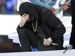 Eminem kneels down during the halftime performance at the NFL Super Bowl 56 football game between the Los Angeles Rams and the Cincinnati Bengals Sunday, Feb. 13, 2022, in Inglewood, Calif. (AP Photo/Chris O'Meara)