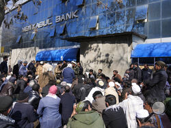 Afghan wait to enter a bank, in Kabul, Afghanistan, Sunday, Feb. 13, 2022. Six months since Kabul was ceded to the Taliban with the sudden and secret departure of U.S.-backed president residents say a calm has settled on the country, but the future is uncertain as the economy teeters on the verge of an economic collapse and the new Taliban rulers tackle the transition from war to relative peace. (AP Photo/Hussein Malla)