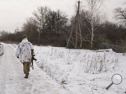 A Ukrainian serviceman walks to a frontline position outside Popasna, the Luhansk region, in eastern Ukraine, Wednesday, Feb. 16, 2022. Ukrainians defied pressure from Moscow with a national show of flag-waving unity Wednesday, while the West warned that it saw no sign of a promised pullback of Russian troops from Ukraine's borders despite Kremlin declarations of a withdrawal. (AP Photo/Vadim Ghirda)