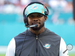 FILE - Miami Dolphins head coach Brian Flores smiles on the sidelines during an NFL football game against the Carolina Panthers, on Nov. 28, 2021, in Miami Gardens, Fla. The Pittsburgh Steelers hired the former Miami Dolphins coach on Saturday, Feb. 19, 2022, to serve as a senior defensive assistant. The hiring comes less than three weeks after Flores sued the NFL and three teams over alleged racist hiring practices following his dismissal by Miami in January. (AP Photo/Doug Murray, File)