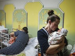 Kateryna Suharokova holds her newborn son Makar in the basement of a maternity hospital converted into a medical ward and used as a bomb shelter in Mariupol, Ukraine, Monday, Feb. 28, 2022. In makeshift shelters and underground railway platforms across Ukraine, families trying to protect the young and old and make conditions bearable amid the bullets, missiles and shells outside. (AP Photo/Evgeniy Maloletka)