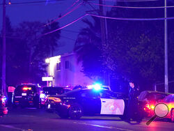 Law enforcement vehicles from several agencies block a street near the scene of a shooting in Sacramento, Calif., Monday, Feb. 28, 2022. (AP Photo/Rich Pedroncelli)
