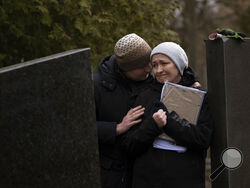 Oksana his hugged by her soon Dmytro during the funeral of her husband Volodymyr Nezhenets, 54, in the city of Kyiv, Ukraine, Friday, March 4, 2022. A small group of reservists are burying their comrade, 54-year-old Volodymyr Nezhenets, who was one of three killed on Feb. 26 in an ambush Ukrainian authorities say was caused by Russian 'saboteurs'. (AP Photo/Emilio Morenatti)