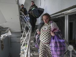 An injured pregnant woman walks downstairs in a maternity hospital damaged by shelling in Mariupol, Ukraine, Wednesday, March 9, 2022. (AP Photo/Evgeniy Maloletka)
