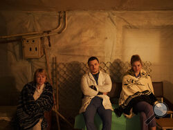 Medical staff sit in a hospital basement, used as a bomb shelter, during an air raid alarm in Brovary, north of Kyiv, Ukraine, Thursday, March 17, 2022. (AP Photo/Felipe Dana)
