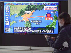 A woman walks along a sidewalk past a TV displaying a news program on North Korea's missile launch Thursday, March 24, 2022, in Tokyo. North Korea has fired a suspected long-range missile toward the sea in what would be its first such test since 2017, raising the ante in a pressure campaign aimed at forcing the United States and other rivals to accept it as a nuclear power and remove crippling sanctions. (AP Photo/Eugene Hoshiko)