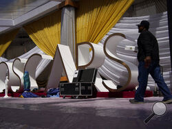 A person walks along the red carpet during preparations for Sunday's 94th Academy Awards outside the Dolby Theatre on Friday, March 25, 2022, in Los Angeles. (AP Photo/John Locher)