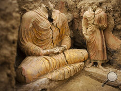 FILE - In this photograph made on Tuesday, Oct. 12, 2010 in Mes Aynak valley, south of Kabul, Afghanistan, Buddha statues are seen inside an ancient temple. The valley is the world's second-largest unexploited copper estimated to be worth nearly $1 trillion. (AP Photo/Dusan Vranic, File)