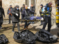 Volunteers collect bodies of murdered civilians, in Bucha, close to Kyiv, Ukraine, Monday, April 4, 2022. Russia is facing a fresh wave of condemnation after evidence emerged of what appeared to be deliberate killings of civilians in Ukraine. (AP Photo/Efrem Lukatsky)