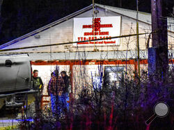 Law enforcement agents investigate the scene of a fatal robbery at Lock Stock & Barrel Shooting Range late Friday, April 8, 2022 in Coweta County, Ga., about 50 miles southwest of Atlanta. Authorities say a couple and their grandson are dead after an armed robbery at the gun range. The Grantville Police Department said via Facebook that the robbery occurred Friday evening. (Clay Neely/The Newnan Times-Herald via AP)