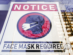 FILE - A sign requiring masks as a precaution against the spread of the coronavirus on a store front in Philadelphia, is seen Feb. 16, 2022. Philadelphia is reinstating its indoor mask mandate after reporting a sharp increase in coronavirus infections, Dr. Cheryl Bettigole, the city's top health official, announced Monday, April 11, 2022. Confirmed COVID-19 cases have risen more than 50% in 10 days, the threshold at which the city's guidelines call for people to wear masks indoors. (AP Photo/Matt Rourke, Fi