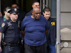 New York City Police and law enforcement officials lead subway shooting suspect Frank R. James, 62, center, away from a police station, in New York, Wednesday, April 13, 2022. The man accused of shooting multiple people on a Brooklyn subway train was arrested Wednesday and charged with a federal terrorism offense. (AP Photo/Seth Wenig)