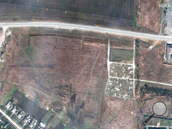 FILE - This satellite image provided by Maxar Technologies on Thursday, April 21, 2022 shows an overview of the cemetery in Manhush, some 20 kilometers west of Mariupol, Ukraine, on April 3, 2022. The graves are aligned in four sections of linear rows (measuring approximately 85 meters per section) and contain more than 200 graves. (Satellite image ©2022 Maxar Technologies via AP)