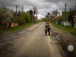 Tetyana Boikiv, 52, right, meets and hugs her neighbour Svitlana Pryimachenko, 48, during a funeral service for her husband, Mykola Moroz, 47, at the Ozera village, near Bucha, Ukraine on Tuesday, April 26, 2022. Mykola was captured by Russian army from his house in the Ozera village on March 13, taken for several weeks in an unknown location and finally found killed with gunshots about 15 kilometres from his house. (AP Photo/Emilio Morenatti)