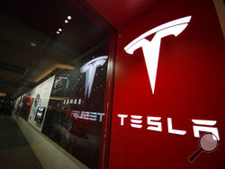 FILE - A sign bearing the company logo outside a Tesla store in Cherry Creek Mall in Denver, Feb. 9, 2019. Elon Musk has sold 4.4 million shares of Tesla stock worth roughly $4 billion, most likely to help fund his purchase of Twitter. (AP Photo/David Zalubowski, File)
