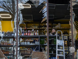 A liquor store owner looks at the damage to his shop caused by an explosion in Kyiv, Ukraine on Friday, April 29, 2022. Russia struck the Ukrainian capital of Kyiv shortly after a meeting between President Volodymyr Zelenskyy and U.N. Secretary-General António Guterres on Thursday evening. (AP Photo/Emilio Morenatti)