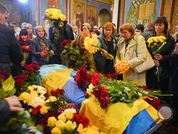 People pay their respects during the funeral ceremony for Ukrainian serviceman Ruslan Borovyk killed by the Russian troops in a battle in St Michael cathedral in Kyiv, Ukraine, Wednesday, May 4, 2022. (AP Photo/Efrem Lukatsky)
