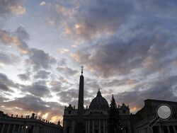FILE - The sun sets behind St. Peter's Basilica, at the Vatican, Thursday, Dec. 5, 2019. The Vatican’s sprawling financial trial may not have produced any convictions yet or any new smoking guns. But recent testimony in May 2022 has provided plenty of insights into how the Vatican operates. (AP Photo/Gregorio Borgia, File)
