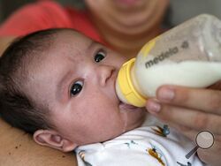 Two-month-old Jose Ismael Gálvez is fed a bottle of formula by his mother, Yury Navas, 29, of Laurel, Md., from her dwindling supply of formula at their apartment in Laurel, Md., Monday, May 23, 2022. After this day's feedings she will be down to their last 12.5 ounce container of formula. Navas doesn't know why her breastmilk didn't come in for her third baby and has tried many brands of formula before finding the one kind that he could tolerate well, which she now says is practically impossible for her to