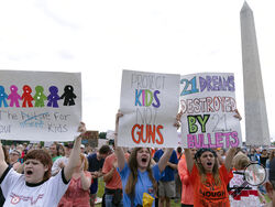 People hold signs in the second March for Our Lives rally in support of gun control in front of the Washington Monument, Saturday, June 11, 2022, in Washington. The rally is a successor to the 2018 march organized by student protestors after the mass shooting at a high school in Parkland, Fla. (AP Photo/Jose Luis Magana)