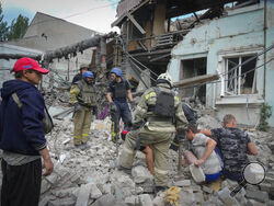 Search and rescue workers and local residents remove a body from under the rubble of a building after a Russian air raid in Lysychansk, Luhansk region, Ukraine, Thursday, June 16, 2022. (AP Photo/Efrem Lukatsky)