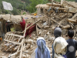 Afghan children stand near a house that was destroyed in an earthquake in the Spera District of the southwestern part of Khost Province, Afghanistan.