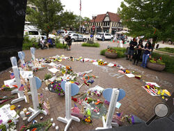 People visit a memorial for those injured and killed in Monday's Fourth of July mass shooting, Wednesday, July 6, 2022, in Highland Park, Ill. (AP Photo/Charles Rex Arbogast)