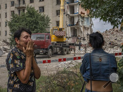 Iryna Shulimova, 59, weeps at the scene in the aftermath of a Russian rocket that hit an apartment residential block, in Chasiv Yar, Donetsk region, eastern Ukraine, Sunday, July 10, 2022. At least 15 people were killed and more than 20 people may still be trapped in the rubble, officials said Sunday. (AP Photo/Nariman El-Mofty)