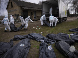 FILE - Volunteers load bodies of civilians killed in Bucha onto a truck to be taken to a morgue for investigation, in the outskirts of Kyiv, Ukraine, Tuesday, April 12, 2022. Ministers from dozens of nations are meeting on Thursday, July 14, 2022 in the Netherlands to discuss with the International Criminal Court’s chief prosecutor how best to coordinate efforts to bring to justice perpetrators of war crimes in Ukraine. (AP Photo/Rodrigo Abd, File)