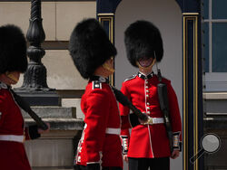 A British soldier, right, wearing a traditional bearskin hat, waits to be relieved from his stint as the guards are changed outside Buckingham Palace, during hot weather in London, Monday, July 18, 2022. The British government have issued their first-ever "red" warning for extreme heat. The alert covers large parts of England on Monday and Tuesday, when temperatures may reach 40 degrees Celsius (104 Fahrenheit) for the first time, posing a risk of serious illness and even death among healthy people, the U.K