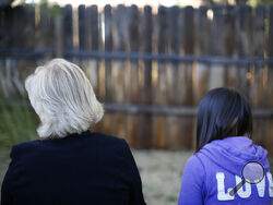 MJ and her adoptive mother sit for an interview with The Associated Press in Sierra Vista, Ariz., Oct. 27, 2021. State authorities placed MJ in foster care after learning that her father, the late Paul Adams, sexually assaulted her and posted video of the assaults on the Internet. (AP Photo/Dario Lopez-Mills)