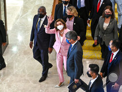 This handout photo taken and released by Malaysia’s Department of Information, U.S. House Speaker Nancy Pelosi, center, waves to media as she tours the parliament house in Kuala Lumpur, Tuesday, Aug. 2, 2022. Pelosi arrived in Malaysia on Tuesday for the second leg of an Asian tour that has been clouded by an expected stop in Taiwan, which would escalate tensions with Beijing. (Malaysia’s Department of Information via AP)