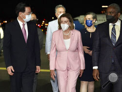 In this photo released by the Taiwan Ministry of Foreign Affairs, U.S. House Speaker Nancy Pelosi, center, walks with Taiwan's Foreign Minister Joseph Wu, left, as she arrives in Taipei, Taiwan, Tuesday, Aug. 2, 2022. Pelosi arrived in Taiwan on Tuesday night despite threats from Beijing of serious consequences, becoming the highest-ranking American official to visit the self-ruled island claimed by China in 25 years. ( Taiwan Ministry of Foreign Affairs via AP)