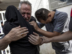 Relatives of Muhammad Hassouna, who was killed in an Israeli airstrike mourn before his funeral outside a hospital in Rafah, in the southern Gaza Strip, Sunday, Aug. 7, 2022. An Israeli airstrike in Rafah killed a senior commander in the Palestinian militant group Islamic Jihad, authorities said Sunday, its second leader to be slain amid an escalating cross-border conflict. (AP Photo/Fatima Shbair)