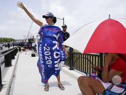 A Donald Trump supporter stands on a bridge outside the entrance to former President Donald Trump's Mar-a-Lago estate, Tuesday, Aug. 9, 2022, in Palm Beach, Fla. The FBI searched Trump's Mar-a-Lago estate as part of an investigation into whether he took classified records from the White House to his Florida residence, people familiar with the matter said Monday. (AP Photo/Lynne Sladky)