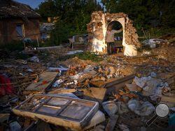 Vladimir, 66, stands next to the wreckage of his house after being bombed by Russians in Chernihiv, Ukraine, Monday, Aug. 29, 2022. On May 3, witnesses heard a plane approaching and dropping bombs that destroyed a large number of houses, including his own, killing five of his relatives who were sleeping at the time. (AP Photo/Emilio Morenatti)