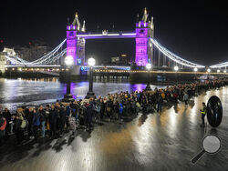 People queue in front of Tower Bridge to pay their respect to the late Queen Elizabeth II during the Lying-in State at Westminster Hall in London, early Saturday morning, Sept. 17, 2022. The Queen will lie in state in Westminster Hall for four full days before her funeral on Monday Sept. 19. (AP Photo/Martin Meissner)