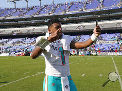Miami Dolphins quarterback Tua Tagovailoa (1) takes a selfie on the field after defeating the Baltimore Ravens at an NFL football game, Sunday, Sept. 18, 2022, in Baltimore. The Dolphins defeated the Ravens 42-38. (AP Photo/Julio Cortez)
