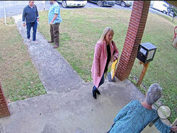 FILE - In this image taken from Coffee County, Ga., security video, Cathy Latham, bottom, chair of the Coffee County Republican Party, greets a team of computer experts from data solutions company SullivanStrickler at the county elections office in Douglas, Ga., on Jan. 7, 2021. Lawyers investigating a breach of voting system data that potentially has put Georgia’s election system at risk are asking a judge to order former Republican Party chair Latham to turn over data from her personal devices, which they
