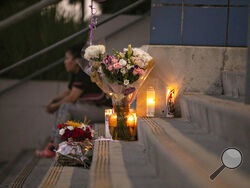 Students and community members place flowers and candles at Helen Bernstein High School where a teenage girl died of an overdose on Thursday, Sept. 15, 2022, in Los Angeles. Authorities said multiple Los Angeles teenagers have overdosed on pills likely laced with fentanyl over the past month, including the 15-year-old girl who died on the high school campus. (Jason Armond/Los Angeles Times via AP)