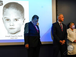 William C. Fleisher, with the Vidocq Society, center, Philadelphia Police Captain Jason Smith, and Dr. Constance DiAngelo, Philadelphia Chief Medical Examiner, listen during during a news conference in Philadelphia, Thursday, Dec. 8, 2022. Nearly 66 years after the battered body of a young boy was found stuffed inside a cardboard box, Philadelphia police have revealed the identity of the victim in the city's most notorious cold case. Police identified the boy as Joseph Augustus Zarelli. (AP Photo/Matt Rourk