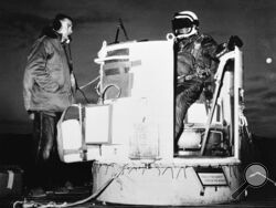 FILE - In this photo provided by the U.S. Air Force, Capt. Joseph Kittinger Jr., aerospace laboratory test director, sits in the open balloon gondola after his first parachute test jump for Project Excelsior at the Air Force Missile Development Center, N.M., Nov. 16, 1959. The gondola carried him at an altitude of 76,400 feet for his record free fall jump of more than 12 miles. At left is David Willard, who designed and developed special equipment for the gondola. Kittinger, the U.S. Air Force pilot who hel