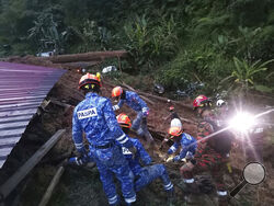 In this photo provided by Civil Defense Department, Civil Defense personnel search for survivors buried after a landslide hit a campsite in Batang Kali, Malaysia, Friday, Dec. 16, 2022. A landslide hit the campsite outside Kuala Lumpur early Friday, Malaysia's fire department said. (Malaysia Civil Defence via AP 