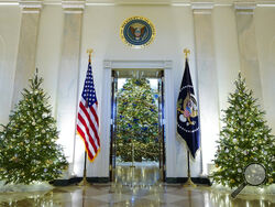 FILE - Cross Hall and the Blue Room of the White House are decorated for the holiday season during a press preview of holiday decorations at the White House, Nov. 28, 2022, in Washington. President Joe Biden celebrated a quiet Christmas with his family at the White House over a record-setting cold and windy weekend in the nation’s capitol. (AP Photo/Patrick Semansky, File)