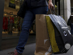 FILE - A shopper carries bags down Fifth Avenue on Black Friday, Nov. 25, 2022, in New York. Holiday sales rose as shoppers showed some resilience during the most important shopping season despite surging prices on everything from food to rent. (AP Photo/Julia Nikhinson, File )